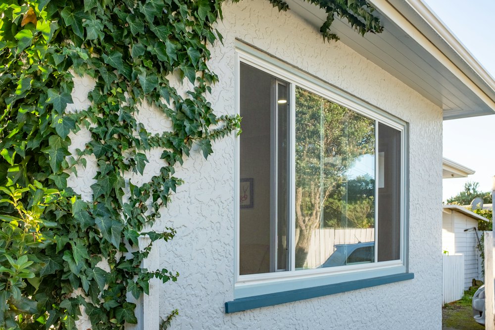 Large window in a white stucco home